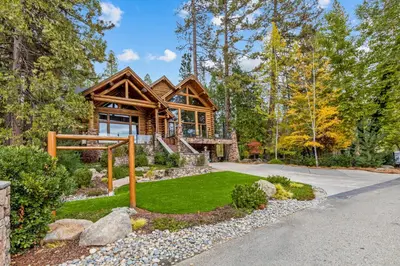 a log cabin in the woods with a driveway at Willow Cove Log Cabin in Bass Lake