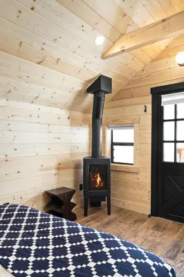a log cabin with a fireplace in a bedroom at Desolation Hotel Hope Valley in Markleeville