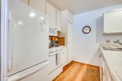 a kitchen with white cabinets and a refrigerator at Mammoth Lakes Condo about 5 Mi to Mammoth Mtn! in Mammoth Lakes