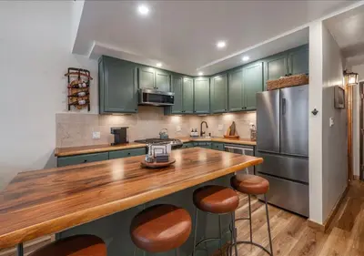 a kitchen with green cabinets and a wooden counter top at Northstar Village Condo Walk to Lifts 2 Full BA Excellent Location Hot-Tubs in Truckee