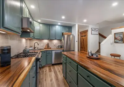 a kitchen with green cabinets and a wooden counter top at Northstar Village Condo Walk to Lifts 2 Full BA Excellent Location Hot-Tubs in Truckee