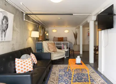 a living room with a couch and a table at Modern lofty studio in Midtown / Charming Old SW in Reno
