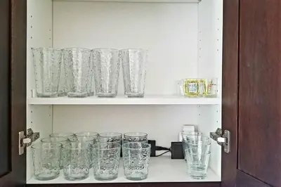 a cabinet filled with glasses on a shelf at Chateau Sunnyside in Fresno
