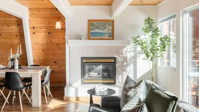 a living room with a fireplace and a table and chairs at Chickaree Chickadee Buyout by AvantStay 2 Sister Cabins in Tahoe City