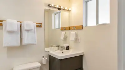 a bathroom with a sink and a toilet and a mirror at Chickaree Chickadee Buyout by AvantStay 2 Sister Cabins in Tahoe City