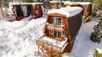 a house is covered in snow at Chickadee by AvantStay Modern A-Frame Cabin in Tahoe City
