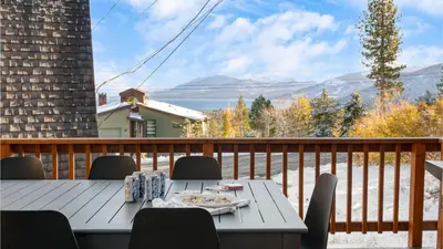 a table on a deck with a view of the mountains at Chickaree by AvantStay A-Frame w Mountain Views in Tahoe City