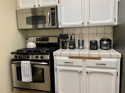 a kitchen with a stove and a microwave at Cozy Cabin Near Yosemite & Bass lake, Breathtaking Views & Private Hot Tub, BBQ, Nature Getaway in Oakhurst
