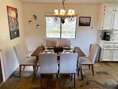 a dining room with a wooden table and chairs at Cozy Cabin Near Yosemite & Bass lake, Breathtaking Views & Private Hot Tub, BBQ, Nature Getaway in Oakhurst