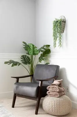 a chair and a ottoman in a room with a plant at Relax at Yosemite, Cozy House with King Bed, Private Hot Tub & Fast Wi-Fi, Near town in Oakhurst