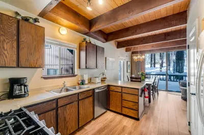 a kitchen with wooden cabinets and a large window at Fairway Forest in Incline Village