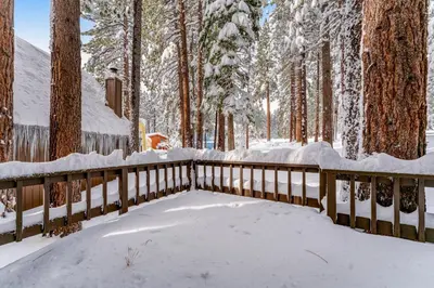 a wooden fence covered in snow next to trees at Fairway Forest in Incline Village