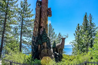 a totem pole with a deer in the background at Talmont Trailhead Cabin in Tahoe City