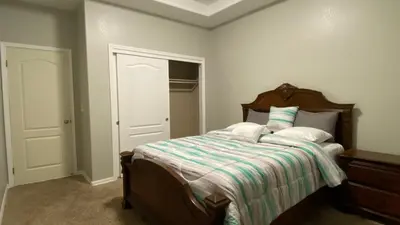 a bedroom with a bed with a striped comforter at Beautiful peaceful desirable home in Madera Rancho in Madera