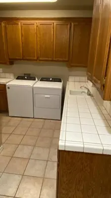 a kitchen with white appliances and wooden cabinets at Beautiful peaceful desirable home in Madera Rancho in Madera