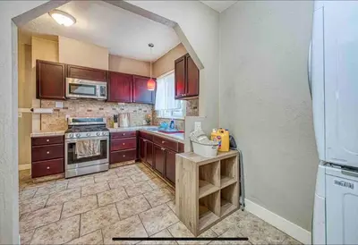 a kitchen with wooden cabinets and a refrigerator at 2 King Beds! Fantastic Stylish Bungalow home! in Fresno