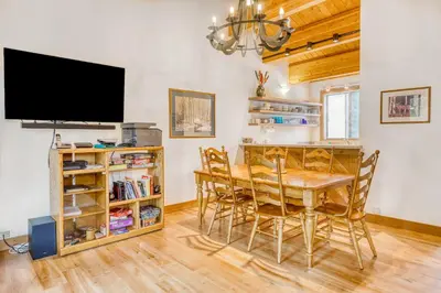 a dining room with a table and a flat screen tv at Evergreen Escape in Truckee