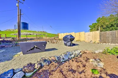 a garden with a umbrella and a stone wall at Peaceful Ranch Home with Sierra Nevada Views in Woodlake