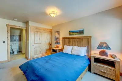 a bedroom with a blue bed and a bathroom at Rocky Revival in Truckee