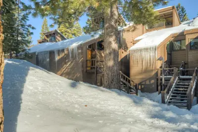 an rv in the snow next to a house at Rocky Revival in Truckee