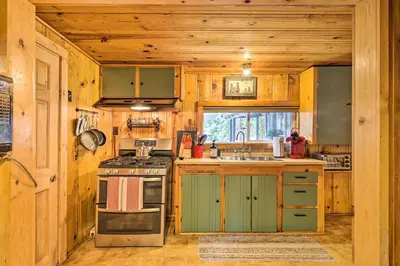 a kitchen with wooden cabinets and a stove at California Retreat with Deck, Fire Pit and Grill! in Long Barn