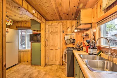 a kitchen with wooden walls and a green refrigerator at California Retreat with Deck, Fire Pit and Grill! in Long Barn
