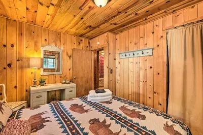 a bedroom with a bed and a wooden wall at California Retreat with Deck, Fire Pit and Grill! in Long Barn