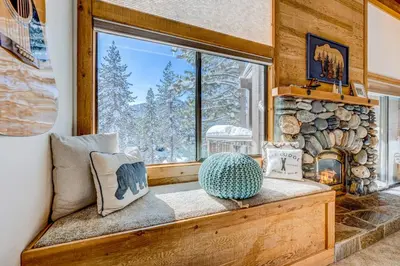 a window seat in a room with a fireplace at The Pines at Rocky Point in Truckee