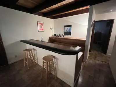 a bar in a room with stools and a sink at Close To Heaven With Hot Tub, Wet Bar & Game Room in South Lake Tahoe