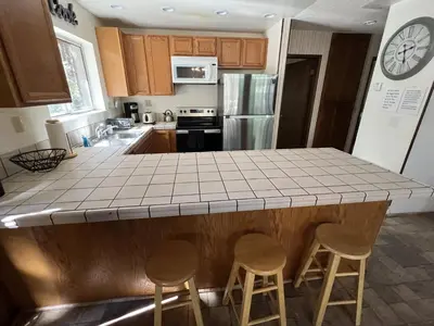 a kitchen with a counter top with stools in it at Close To Heaven With Hot Tub, Wet Bar & Game Room in South Lake Tahoe
