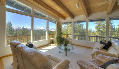 a large screened in porch with couches and a table at Enviable Lake & Mountain Views Wth Waterfall in South Lake Tahoe