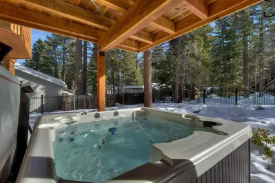 a hot tub in the snow under a pergola at Brand New Upscale Home, Hot Tub, Foosball in South Lake Tahoe