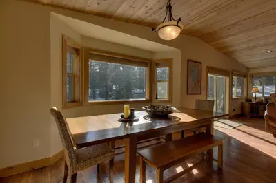 a dining room with a wooden table and chairs at Brand New Upscale Home, Hot Tub, Foosball in South Lake Tahoe