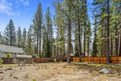a backyard with a fence and trees and a house at Newly Renovated, Foosball Table in South Lake Tahoe