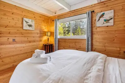 a bedroom with wooden walls and a bed with a window at Newly Renovated, Foosball Table in South Lake Tahoe