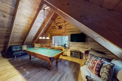 a living room with a pool table in a cabin at Walkup Pines in South Lake Tahoe