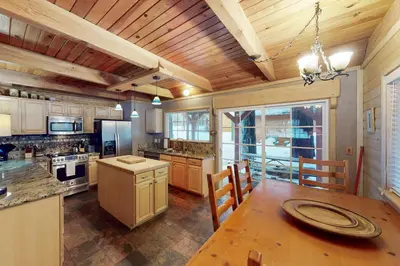 a large kitchen with a wooden ceiling and a table at Walkup Pines in South Lake Tahoe