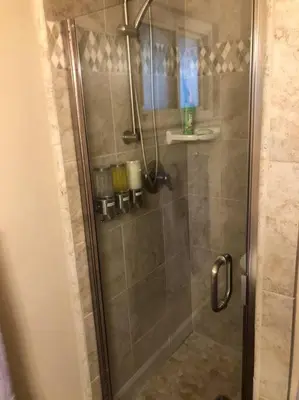 a shower with a glass door in a bathroom at X-Large Spacious Deluxe House Fastest Wi-Fi in Fresno