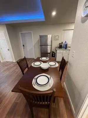 a dining room table with chairs and a kitchen at Brand New 2BR CUTE Blue LED in North Fresno in Fresno