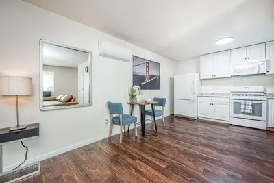 a kitchen with white cabinets and a table and chairs at Totally New Awesome North Fresno Back Studio in Fresno