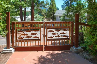 a wooden gate with horses on it in a yard at Willow Cove Lodge- 5 bedrooms with a hot tub in Bass Lake
