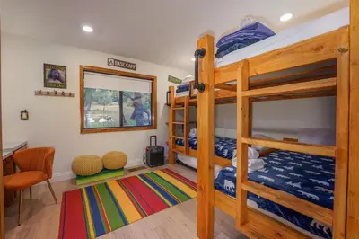 a bedroom with two bunk beds and a desk at Summit Cabin Stunning home Loaded with amenities in Oakhurst