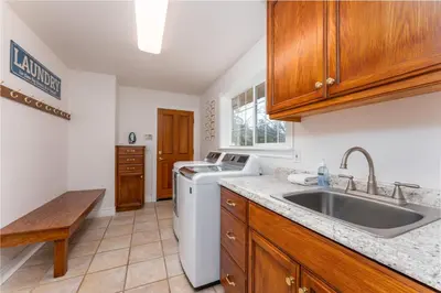 a kitchen with a sink and a washing machine at Yosemite Adventure House with Pool-hot tub-game room in Oakhurst