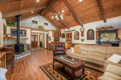a living room with a couch and a table at Oak Pond Retreat Stocked pond/pool table/BBQ Grill/EV Charger in Oakhurst