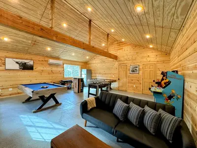 a living room with a couch and a pool table at Log Cabin w/ pool, spa, game room, sleeps 20 in Coarsegold