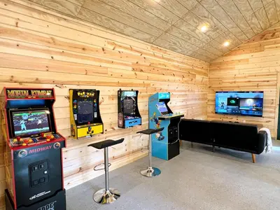 a room with two video game machines and a arcade at Log Cabin w/ pool, spa, game room, sleeps 20 in Coarsegold