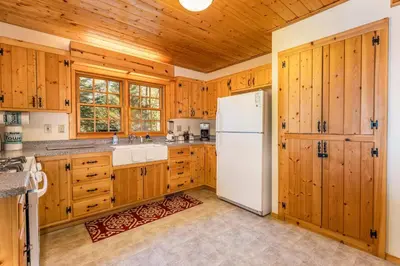 a kitchen with wooden cabinets and a white refrigerator at Place to Call Home - Cabin INSIDE Yosemite - Dog Friendly in South Wawona