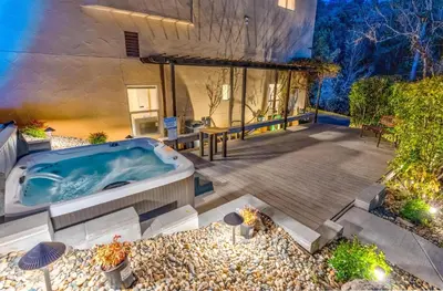 a jacuzzi tub in the backyard of a house at Big Oak Manor w/theater/hot tub/sauna/more in Oakhurst