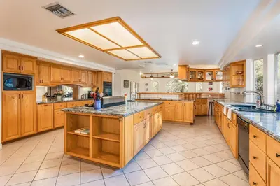 a large kitchen with wooden cabinets and granite counter tops at Big Oak Manor w/theater/hot tub/sauna/more in Oakhurst