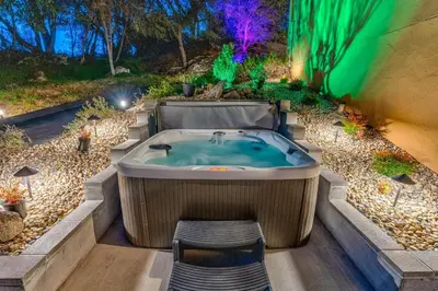 a jacuzzi tub in the middle of a garden at Big Oak Manor w/theater/hot tub/sauna/more in Oakhurst